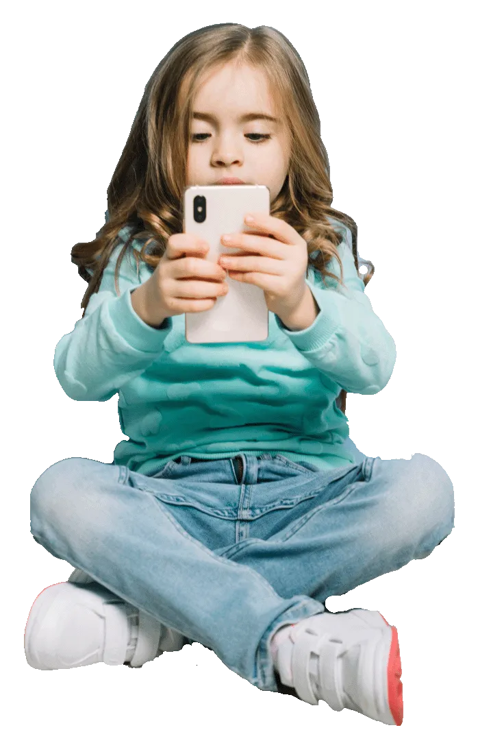 niña sentada con los piés cruzados y mirando un móvil que sujeta con las dos manos